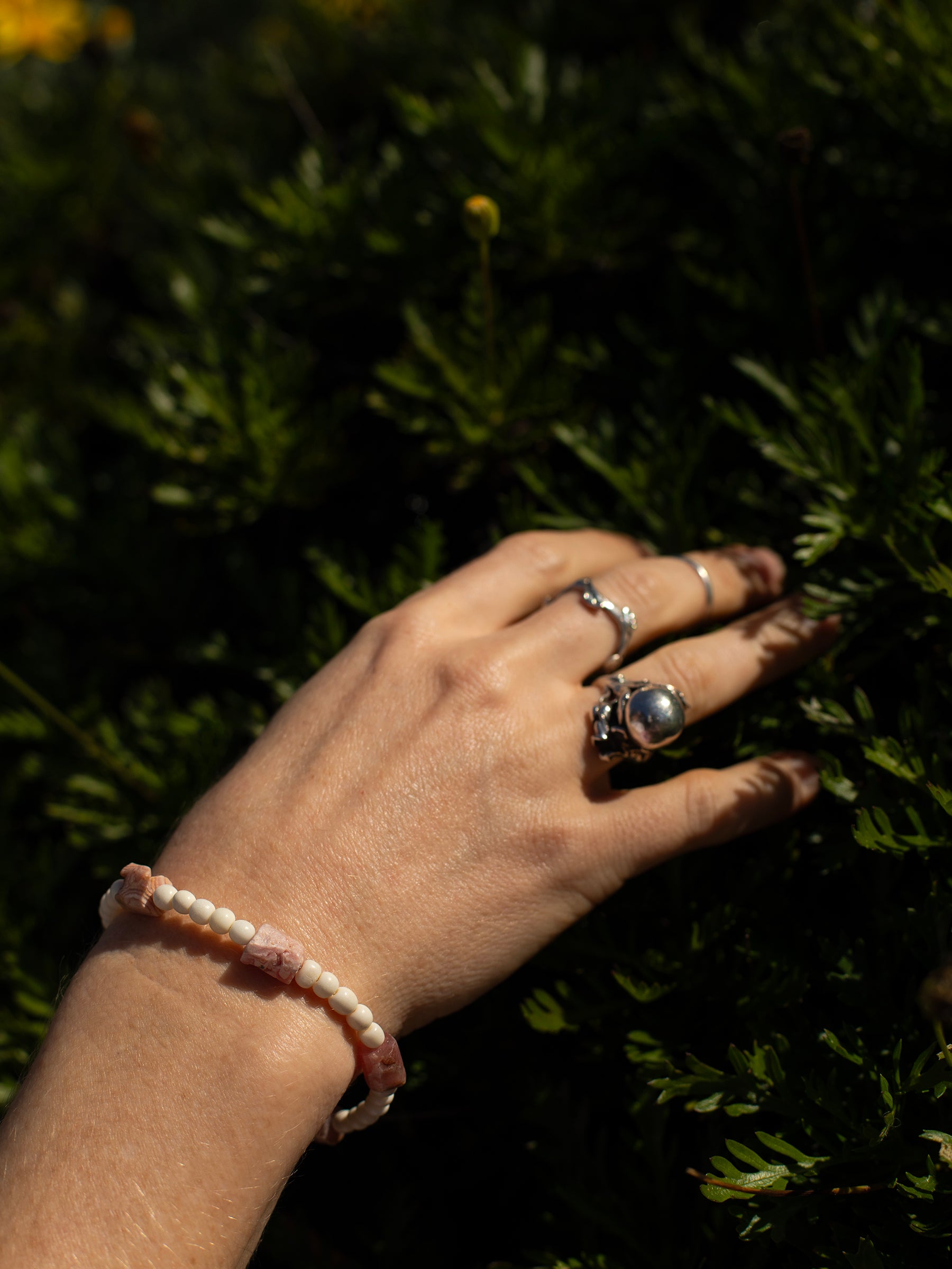 One-of-a-kind natural crystal & cow bone designer bracelet with sterling silver hardware, designed & handmade in California. Crystals are Rhodochrosite.