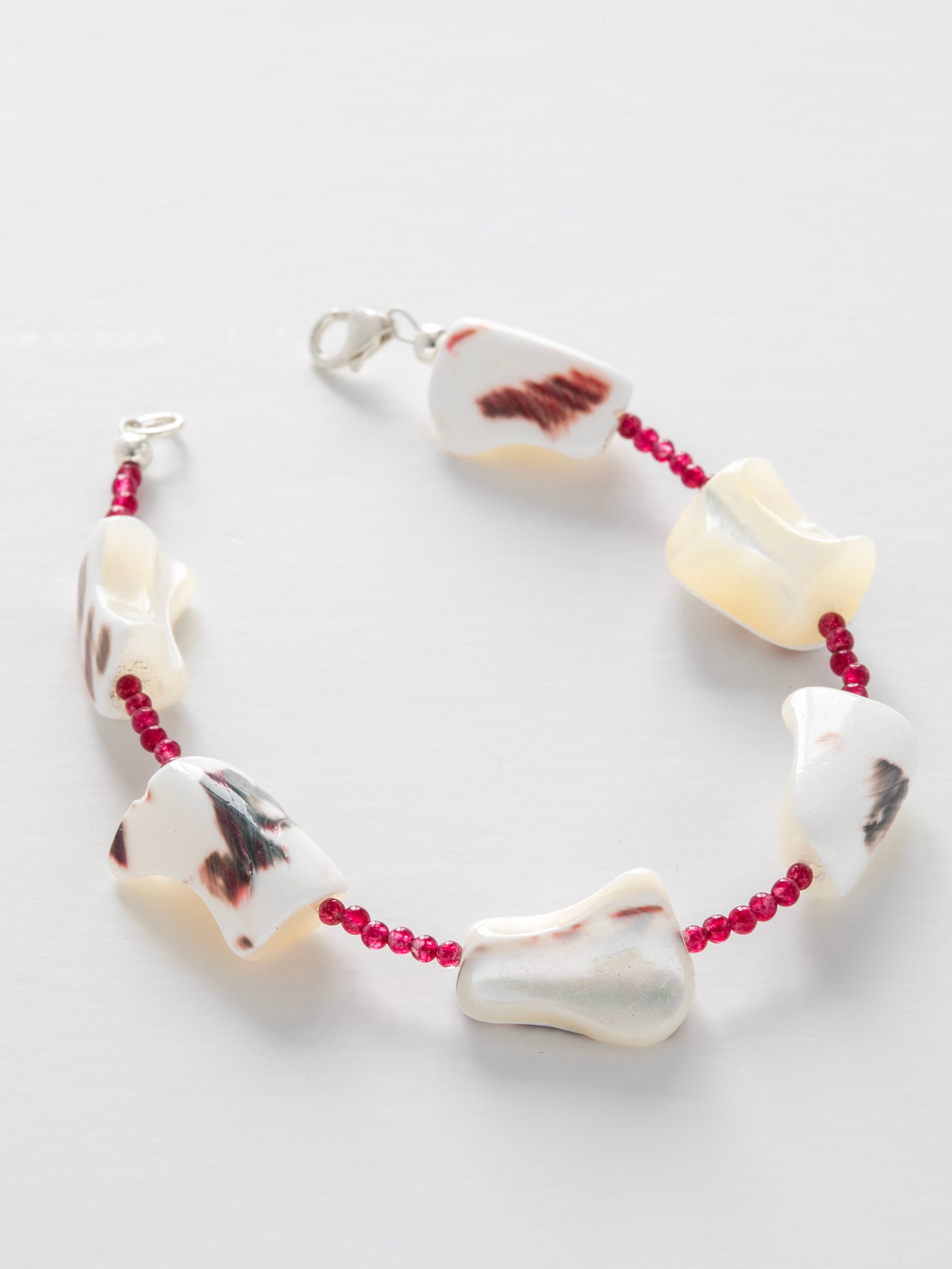 One-of-a-kind natural crystal & shell designer bracelet with sterling silver hardware, designed & handmade in California. Crystals & shells include Red Garnet & Mother of Pearl.