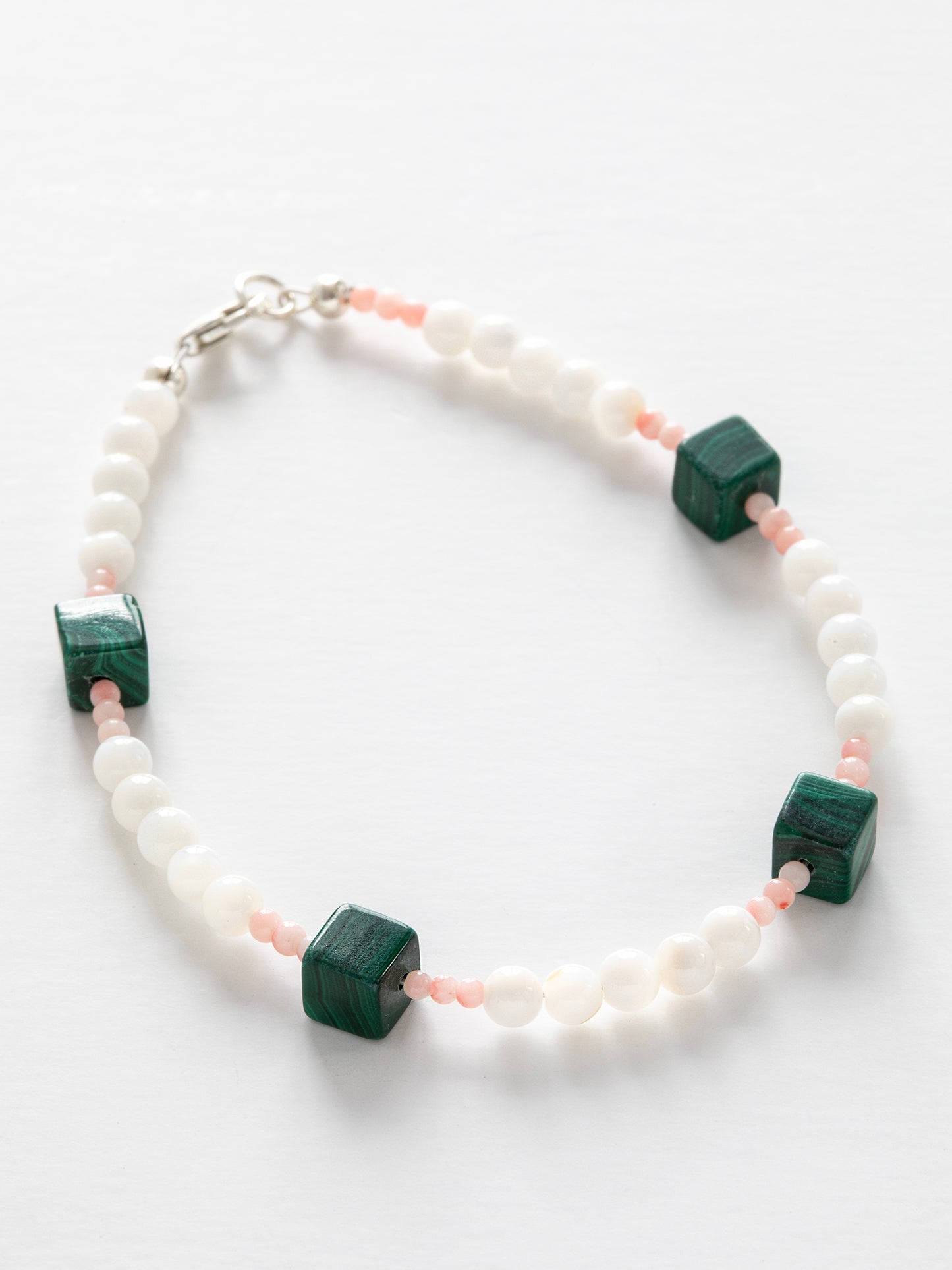 One-of-a-kind natural Pink Coral, Malachite, & Mother of Pearl designer bracelet with sterling silver hardware, designed & handmade in California.