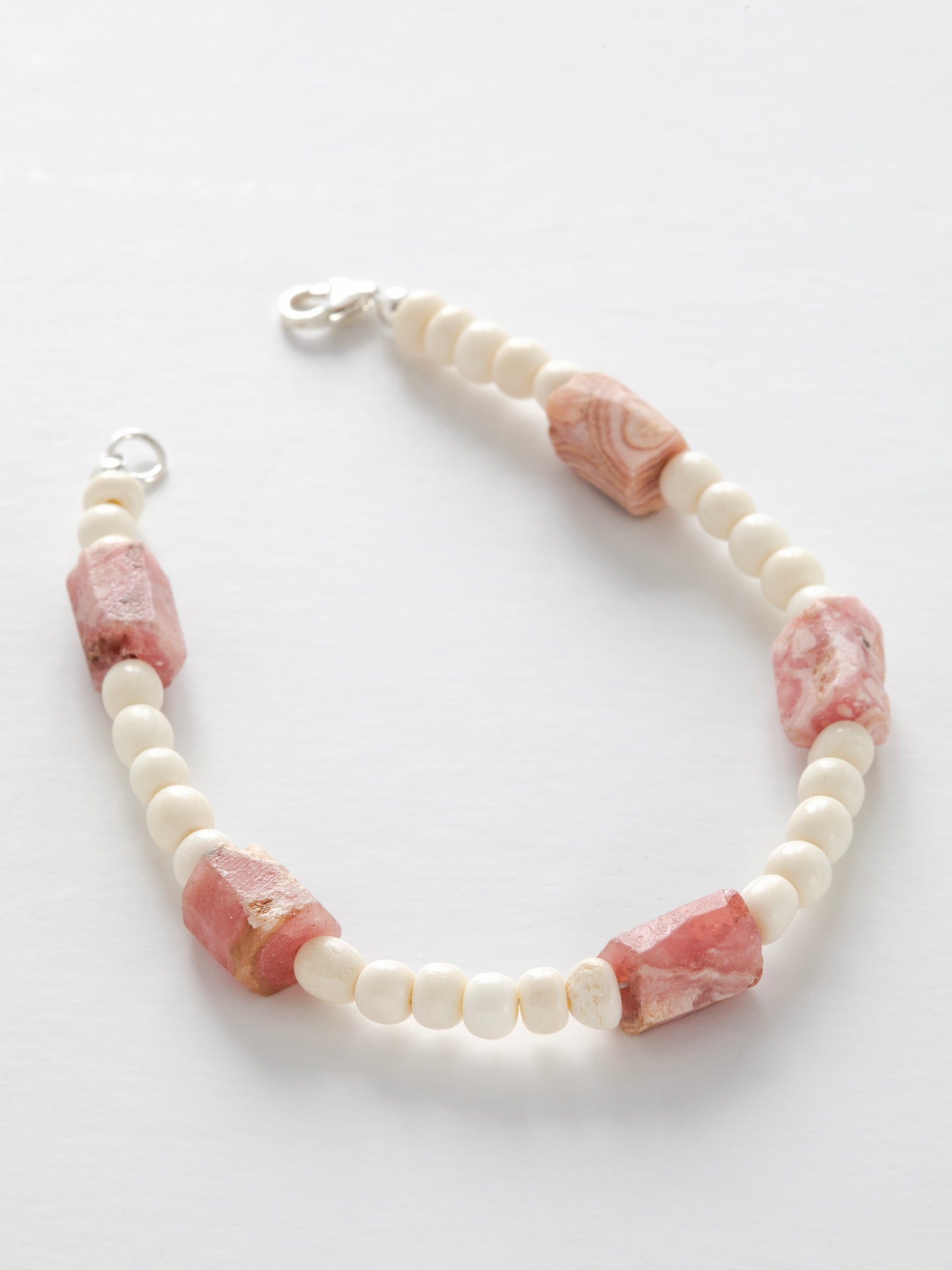 One-of-a-kind natural crystal & cow bone designer bracelet with sterling silver hardware, designed & handmade in California. Crystals are Rhodochrosite.