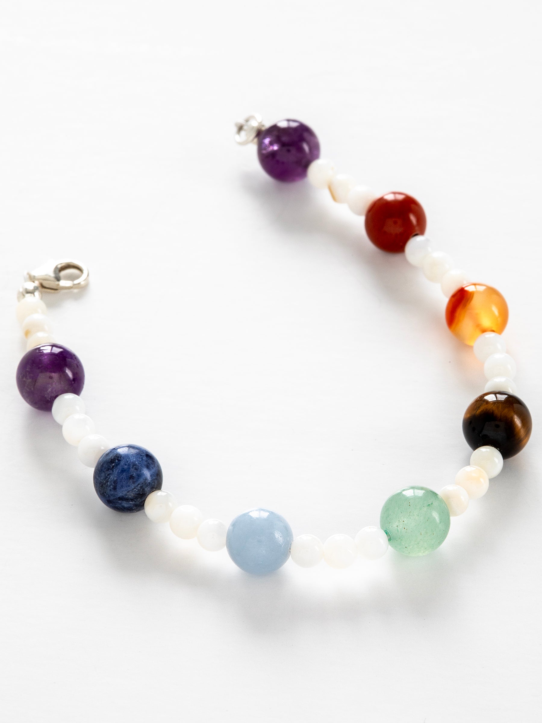 One-of-a-kind natural crystal & shell designer bracelet with sterling silver hardware, designed & handmade in California. Crystals & stones include Amethyst, Aventurine, Blue Lapis, Carnelian, Light Blue Calcite, Mother of Pearl, Red Jasper, and Tiger's Eye.