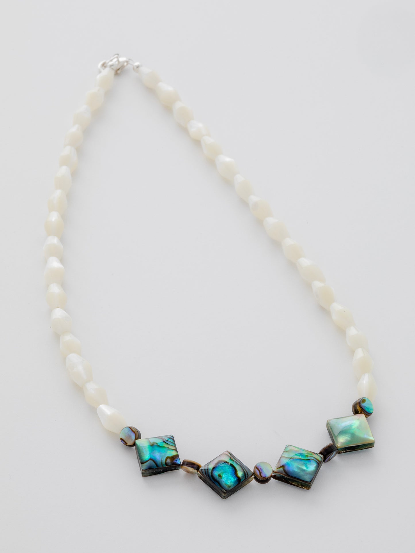 One-of-a-kind natural shell designer necklace with sterling silver hardware, designed & handmade in California. Shells include Mother of Pearl & Abalone.