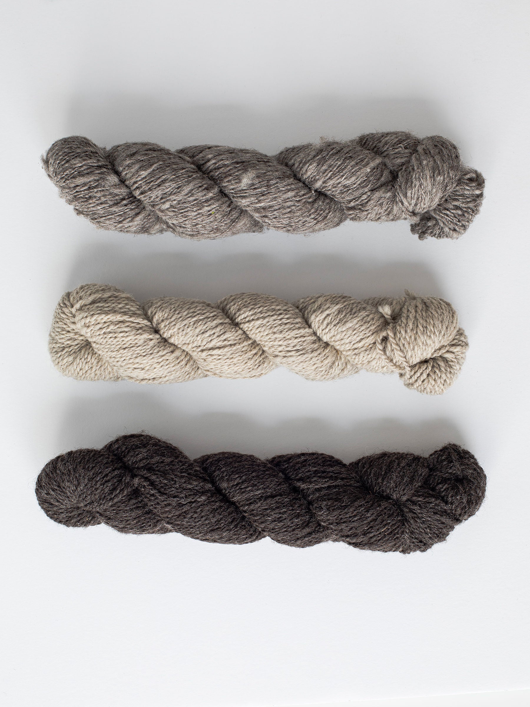 Natural, un-dyed wool yarn in Cream, Light Grey, & Dark Grey colors, each skein is 120 yards (109.7 meters), sourced from Jacob sheep raised in California.