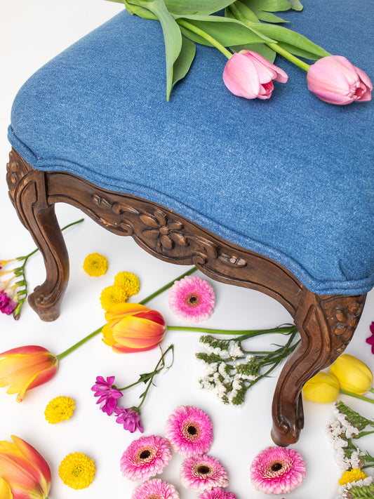 Vintage Floral Hand-Carved Wood & Denim Upholstered Stool, Deep Brown and Indigo Blue colors, Hand-carved wood, Floral daisy design carved in the wood, Newly re-upholstered with indigo denim, Mid Century, Not flawless, small chip in the wood, priced accordingly, Sourced in California.