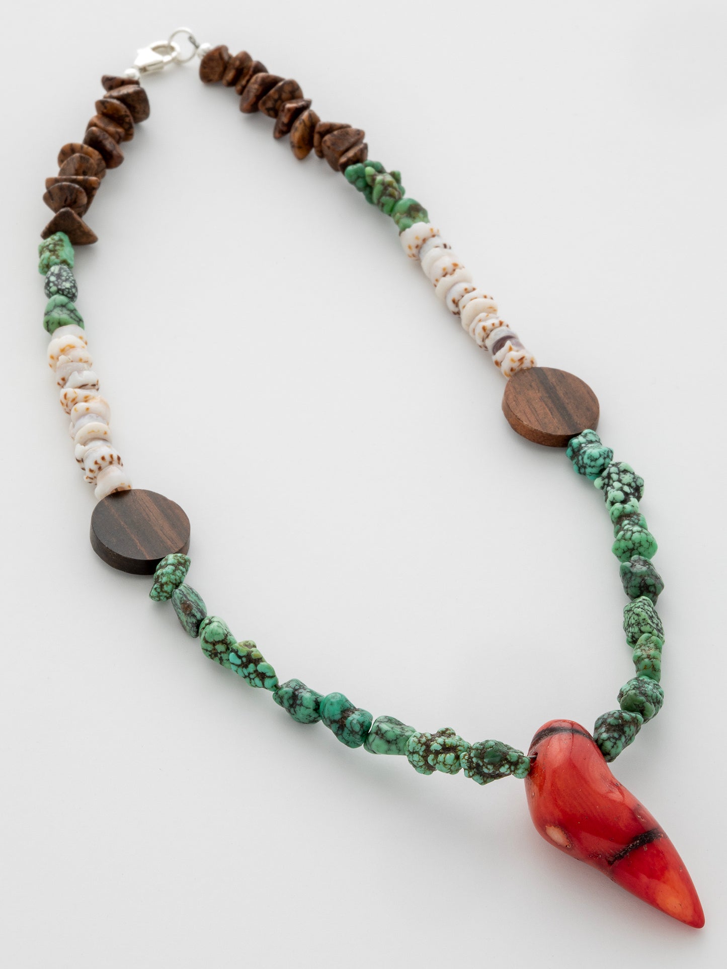 One-of-a-kind natural stone, shell, & wood designer bracelet with sterling silver hardware, designed & handmade in California. Stones & shells include Coconut Shells, Natural Puka Shells, Red Coral, & Turquoise.