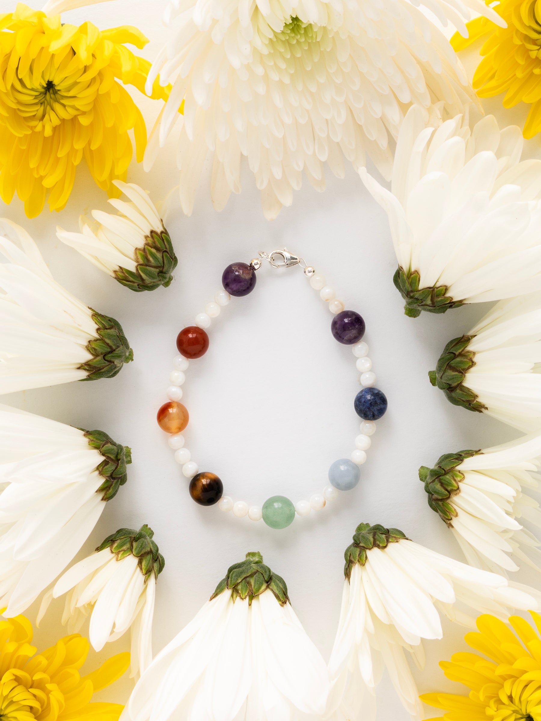 One-of-a-kind natural crystal & shell designer bracelet with sterling silver hardware, designed & handmade in California. Crystals & stones include Amethyst, Aventurine, Blue Lapis, Carnelian, Light Blue Calcite, Mother of Pearl, Red Jasper, and Tiger's Eye.