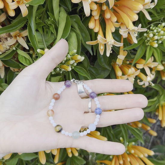 One-of-a-kind natural crystal & shell designer bracelet with sterling silver hardware, designed & handmade in California. Crystals & stones include Amethyst, Aventurine, Blue Lapis, Carnelian, Light Blue Calcite, Mother of Pearl, Red Jasper, and Tiger's Eye.