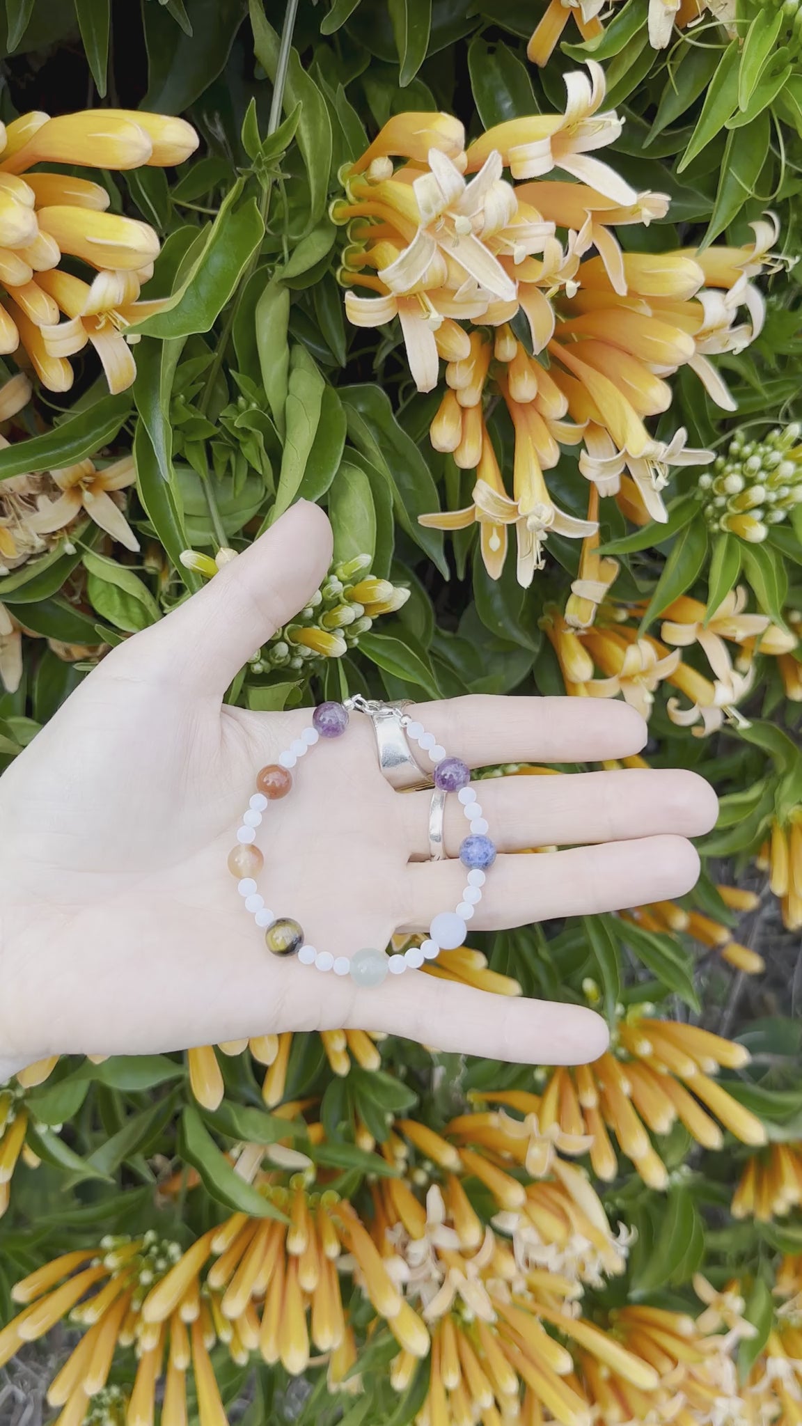 One-of-a-kind natural crystal & shell designer bracelet with sterling silver hardware, designed & handmade in California. Crystals & stones include Amethyst, Aventurine, Blue Lapis, Carnelian, Light Blue Calcite, Mother of Pearl, Red Jasper, and Tiger's Eye.